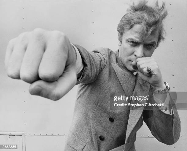 English actor Michael Caine, throwing a punch, August 1965.