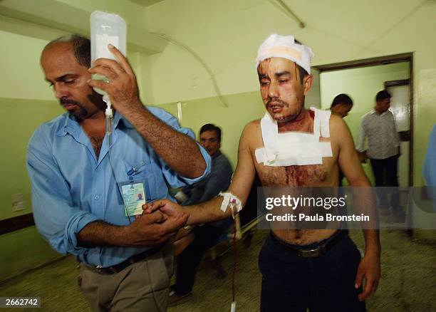 Bombing victim from the Al Khadra police station is helped to his bed at the Al Jarmouk hospital October 27, 2003 in Baghdad Iraq. The police station...