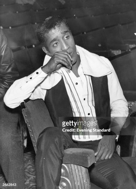 American singer, dancer, comedian and all round entertainer, Sammy Davis Jnr watches the stage at the Prince of Wales Theatre in London. Original...