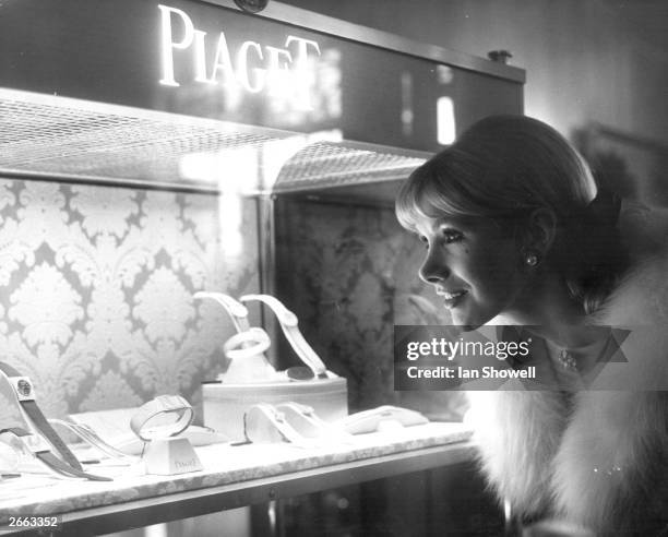 English actress, Susan Hampshire looks at an exhibition case containing Piaget watches, at Asprey's of Bond Street, London.