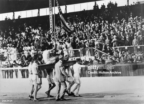 John Hayes of the USA is carried by team-mates on a table with the trophy for winning the Marathon at the 1908 London Olympics.
