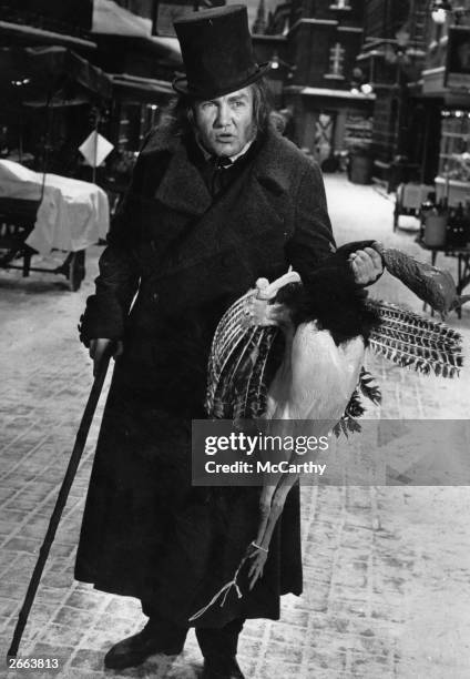 English actor Albert Finney playing the part of Scrooge during the filming of the musical 'Scrooge', adapted from the story 'A Christmas Carol' by...