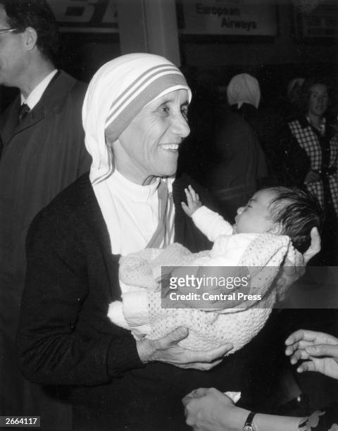 Christian missionary Mother Teresa of Calcutta holding a baby at Heathrow Airport, London.