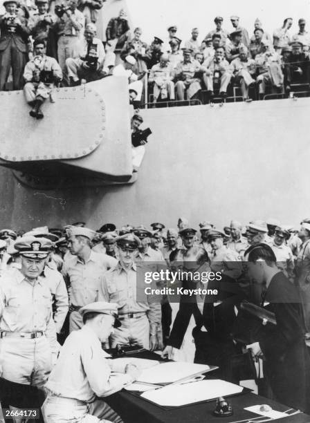 Japanese Foreign Minister, Mamoru Shigemitsu discussing surrender documents with Lt General Richard K Sutherland , Rear Admiral Forrest Sherman is...