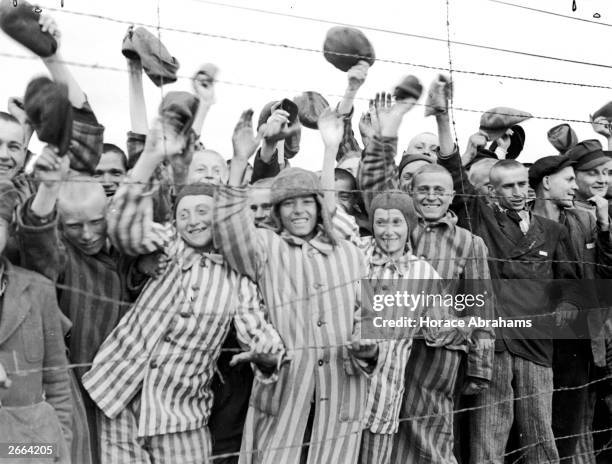 Young prisoners interned at Dachau concentration camp cheering their liberators, the 42nd Division of the US Army. The boy second from left has been...