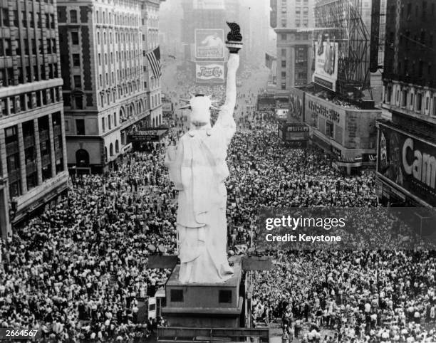 Crowds cheering on Great White Way, New York City, as President Truman announces the formal signing of the Japanese Instrument of Surrender at the...