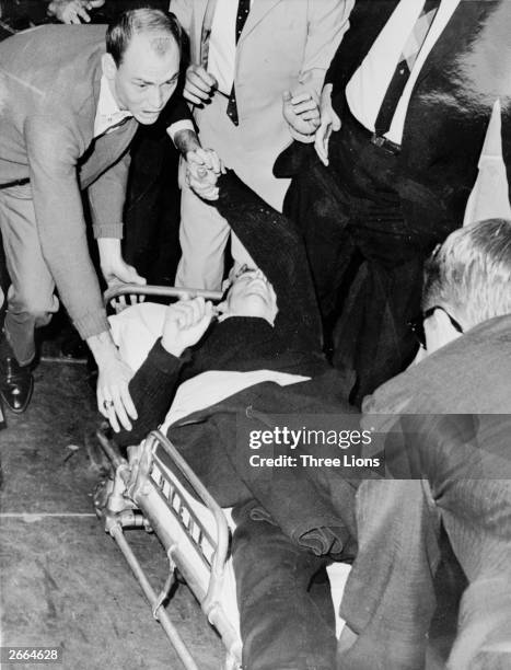 President John F Kennedy's alleged assassin Lee Harvey Oswald is hurried into an ambulance after being shot at Dallas City Prison by night club owner...