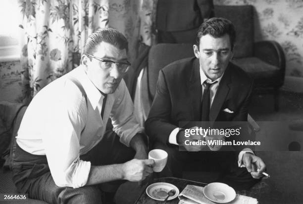 London gangsters Ronnie and Reggie Kray at home having a cup of tea. They had just spent 36 hours being questioned by the police about the murder of...