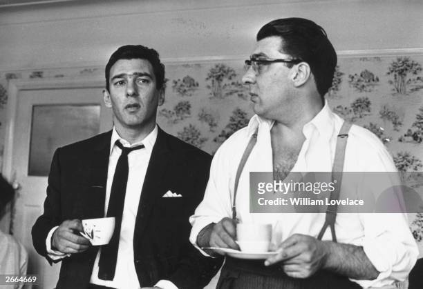 London gangsters Ronnie and Reggie Kray at home having a cup of tea. They had just spent 36 hours being questioned by the police about the murder of...