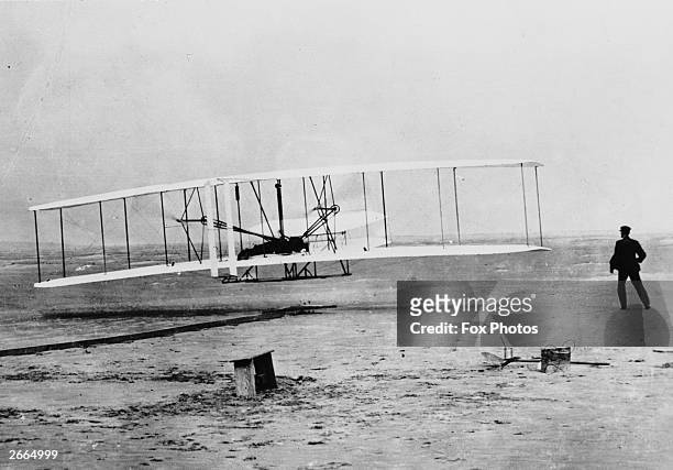 Orville Wright flying a Wright glider fitted with a Wright-designed 12hp engine at Kill Devil Hills, near Kitty Hawk, North Carolina. The flight was...