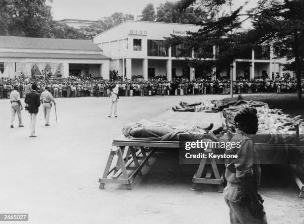 Crowd of onlookers in the background sees the bodies of thieves executed in the Central African Republic under decree by President Jean Bedel...