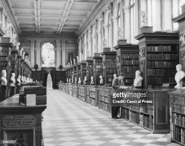 Interior of Trinity College Library, Cambridge designed by Sir Christopher Wren. It houses over 50,000 volumes and the busts are of former fellows...