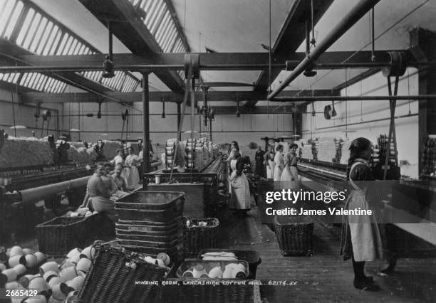 Women operating looms in the winding room of a Lancashire cotton mill.
