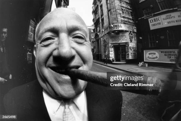 Boxing entrepreneur Jack Solomons enjoying a cigar. In the background are the Windmill Cinema and the Lyric Theatre in London's Soho.