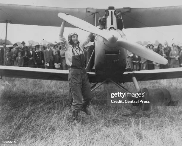 Miss D Spicer cranking the engine of her plane at the first All Women's Flying Meeting in Northamptonshire.