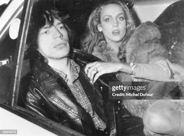 Rolling Stones singer Mick Jagger travels in the back seat of a car with his Texan fashion model girl friend Jerry Hall, in Paris.