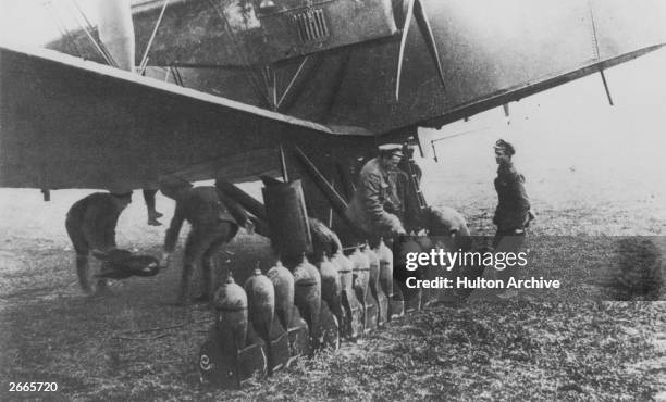 High explosive incendiary bombs being loaded onto a Handley Page bomber at Cramaille, France.