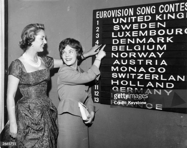 Eurovision Song Contest compere Katie Boyle checks the scoreboard for the order of the draw with Katy Bodtger of Denmark.