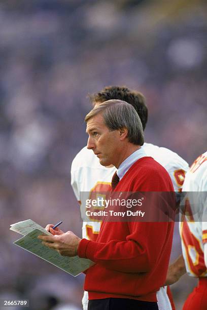Head coach John Mackovic of the Kansas City Chiefs reviews his playsheet during a 1986 NFL game against the Los Angeles Raiders at the LA Memorial...
