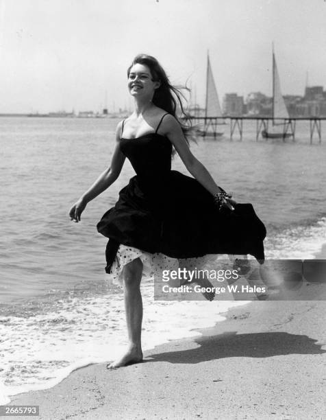 Running barefoot on the sands at Cannes, French film star, Brigitte Bardot .