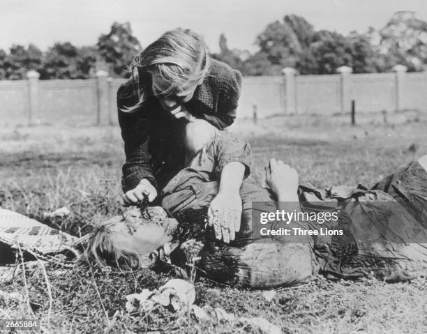 Woman tends to a victim of Nazi atrocities in Poland, during World War II.