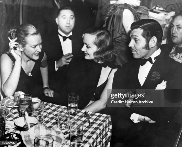Actors Clark Gable and Carole Lombard , who were married the same year, dine out with Eddie Adams.