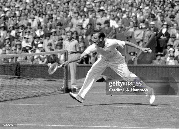 English tennis star Fred Perry stretches to return a shot during his semi-final match against Donald Budge of the USA at the Wimbledon Lawn Tennis...
