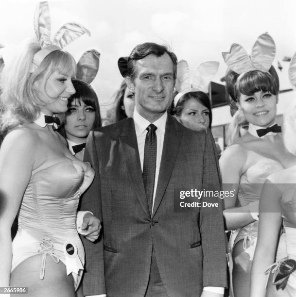 Playboy editor and tycoon Hugh Hefner is greeted by a group of bunny girls from his Playboy Clubs, upon his arrival at London Airport.