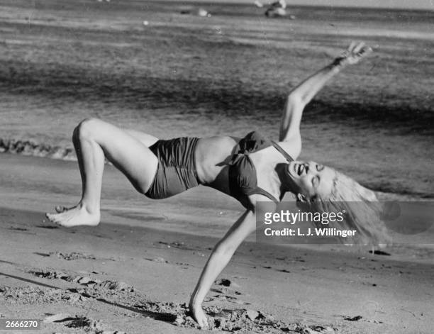 Marilyn Monroe frolicking on the beach near her Hollywood home during a break from filming.