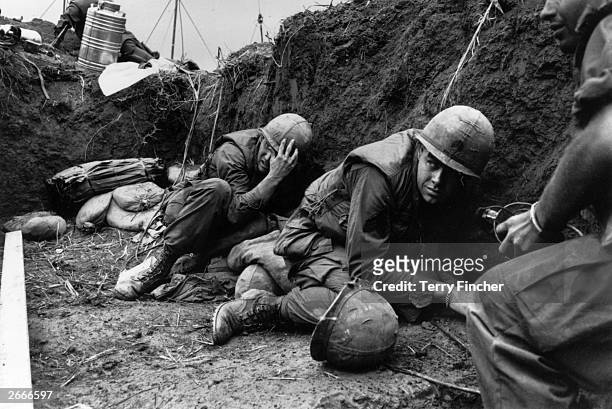 Troops take cover from the Vietcong in a trench on Hill Timothy, during the Vietnam War.