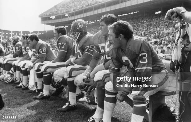 Members of the Denver Broncos, an American football team on the bench.