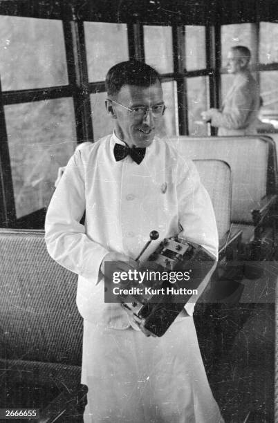 Waiter summoning passengers to dinner with his xylophone on a Canadian Pacific Railway train crossing Canada. Original Publication: Picture Post -...