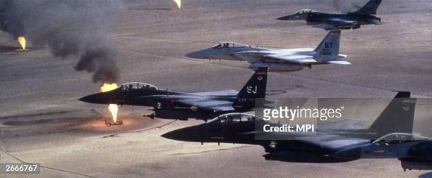 American airforce F-15 C fighters flying over a Kuwaiti oilfield which had been torched by retreating Iraqi troops during the Gulf War.