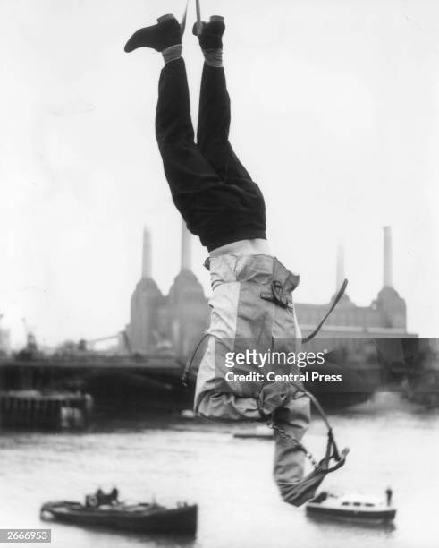 Escapology adviser Timothy Dill-Russell hanging upside down over the Thames while trying to escape from a straight jacket, a trick performed by...