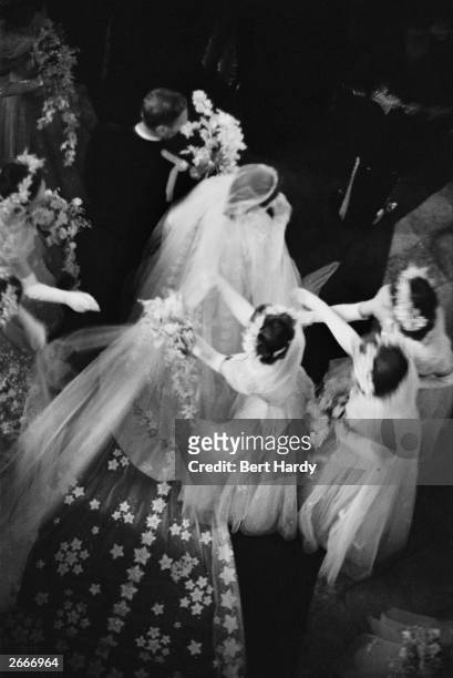 Bridesmaids arranging Princess Elizabeth's veil and train as she arrives at Westminster Abbey, London, with her father King George VI, for her...