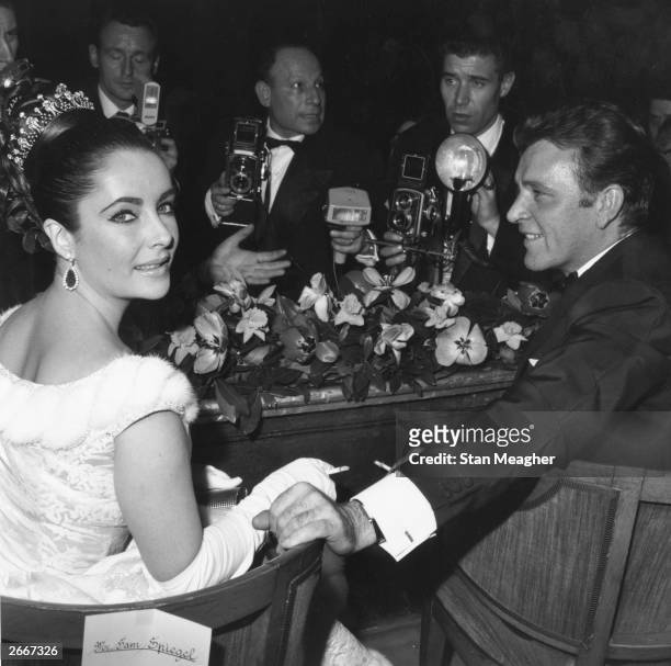 Welsh screen and stage actor Richard Burton and screen actress Elizabeth Taylor with photographers at a screening of David Lean's 'Lawrence of...