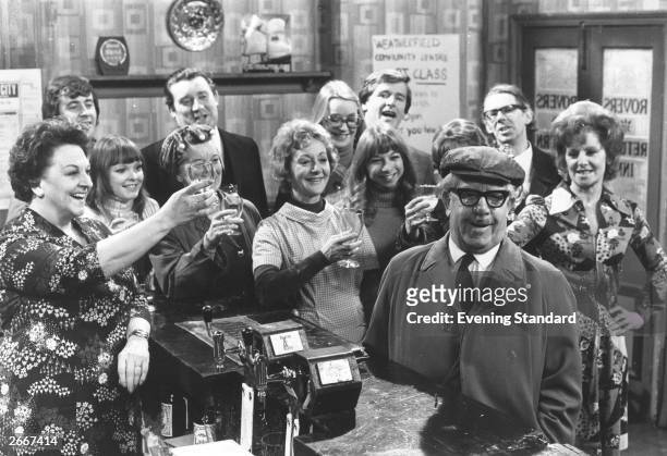 Some of the cast of the British television soap opera, 'Coronation Street' raise a toast in the bar of the show's pub The Rovers Return, circa 1978....