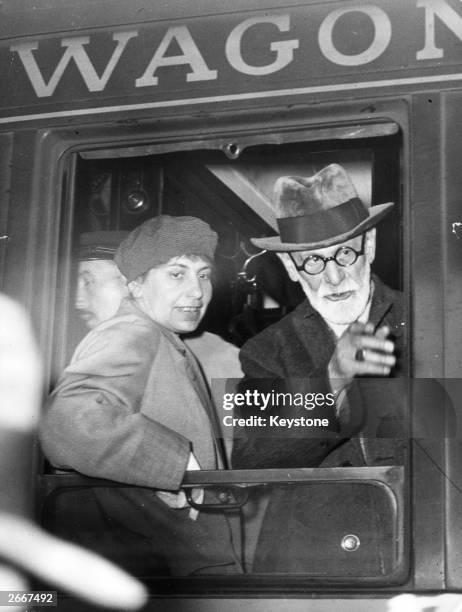 Neurologist and a founder of psychoanalysis, Sigmund Freud at the window of a wagon-lit on arrival at the Gare de l'Est, Paris. He is accompanied by...