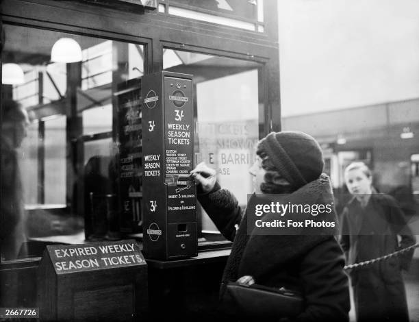 Traveller buys a London Underground season ticket from a vending machine at Highgate Station in London.