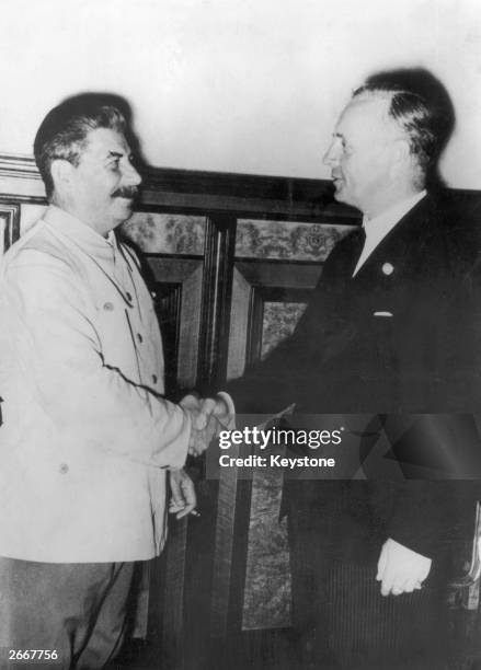 Russian leader Joseph Stalin shakes hands with Joachim von Ribbentrop , the German foreign minister, in Moscow, during discussions on developments in...