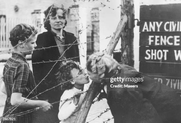 Dutch woman kisses her grandchild for the first time through the barbed wire fence which divides the mining town of Kerkrade in two on the...