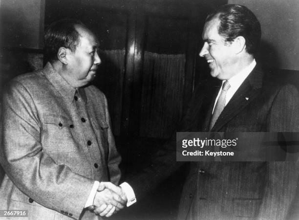 Chinese communist leader Chairman Mao Zedong shakes hands with American president Richard Nixon in Peking during his visit to China.