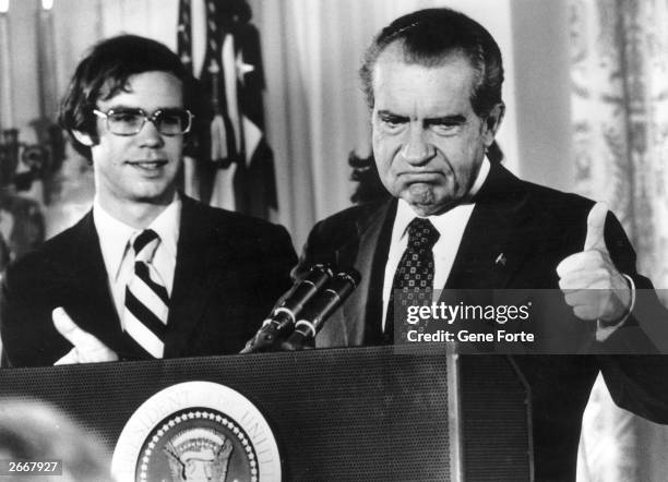 Richard Nixon gives the thumbs up after his resignation as 37th President of the United States. His son-in-law David Eisenhower is with him as he...