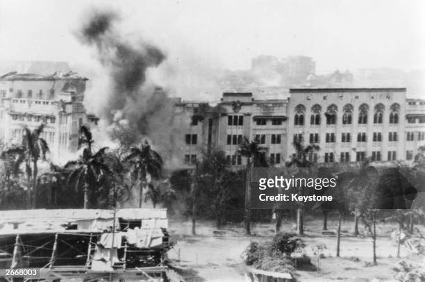 Smoke and flames pour from the old walled city as American troops bombard the Japanese garrison holding out in the old part of Manila.