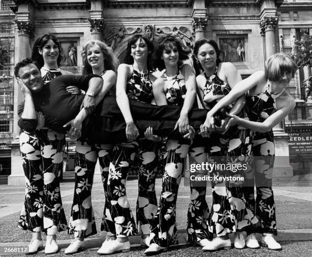 Singer Dickie Valentine being carried by the girls who are to appear in 'The Dickie Valentine Show'. The girls who are all dancers are l to r; Diane...