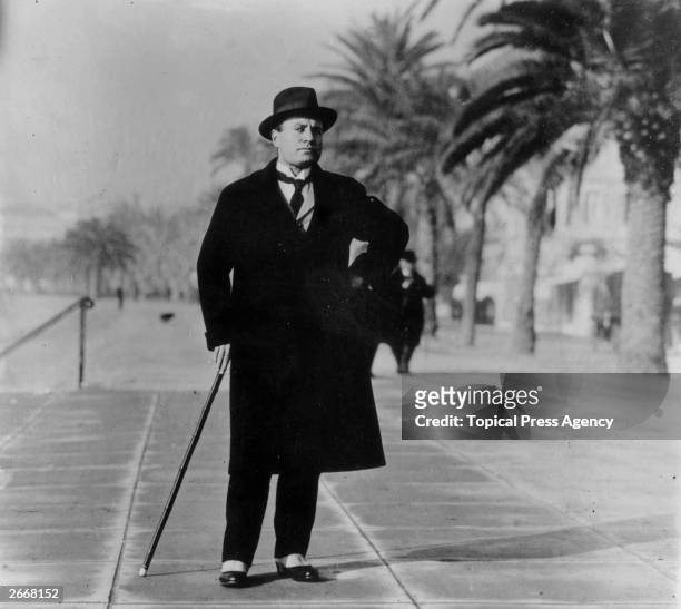 Italian dictator Benito Mussolini wearing spats and an overcoat on the Boulevard at Biarritz, France.
