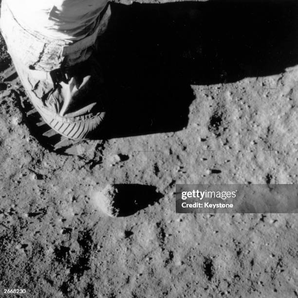 Part of Buzz Aldrin's leg, foot and footprint on the surface of the moon during the Apollo 11 lunar mission.