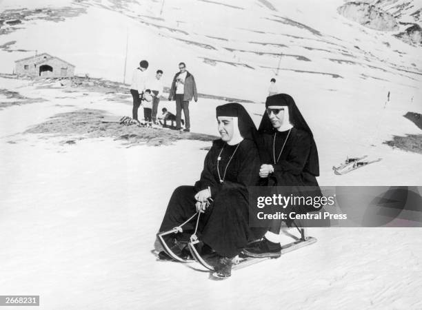 Two nuns from the Missionaries of Nazareth enjoying a downhill sledge ride near the Costa Brave in Nuria, Gerona, Spain.