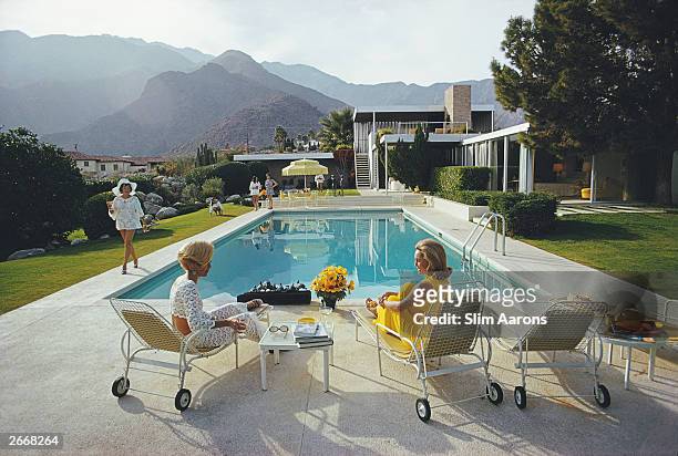 Premium Rates Apply. A desert house in Palm Springs designed by Richard Neutra for Edgar J. Kaufmann. Lita Baron approaches Helen Dzo Dzo and Nelda...