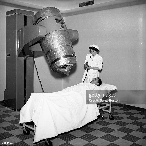 During cobalt 'bomb' treatment of a patient at the Hartmann Clinic in Neuilly-sur-Seine, Paris, a nurse keeps an eye on a geiger counter to monitor...